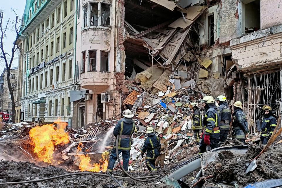 Rescuers work next to a building damaged by air strike in Kharkiv (REUTERS)