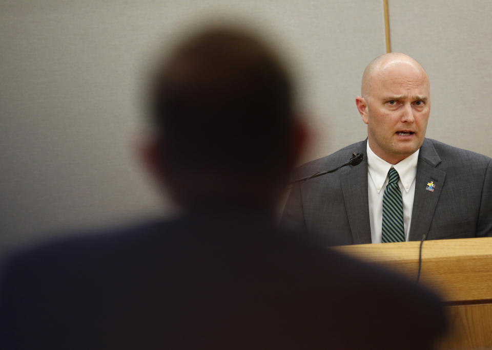Fired Balch Springs police officer Roy Oliver, who is charged with the murder of 15-year-old Jordan Edwards, is cross-examined by lead prosecutor Michael Snipes, foreground, during the sixth day of his trial at the Frank Crowley Courts Building in Dallas on Thursday, Aug. 23, 2018. (Rose Baca/The Dallas Morning News via AP, Pool)