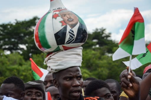 A supporter of Burundi?s ruling CNDD-FDD party balances a gourd on his head with the image of President Nkurunziza at a pre-referendum rally