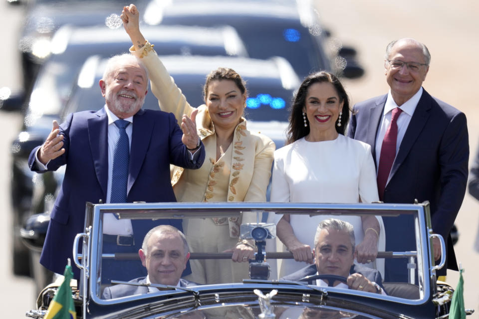 President-elect Luiz Inacio Lula da Silva, left, his wife Rosangela Silva, second from left, Vice President-elect Geraldo Alckmin, right, and his wife Maria Lucia Ribeiro, ride on an open car to Congress for their swearing-in ceremony, in Brasilia, Brazil, Sunday, Jan. 1, 2023. (AP Photo/Andre Penner)