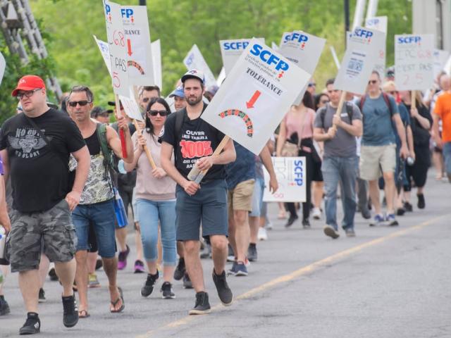 Some of the 521 striking croupiers march to the Montreal Casino on May 21. Labour experts and unions say many workers are prepared to strike this summer in order to gain better pay and conditions amid the soaring cost of living.  (Graham Hughes/The Canadian Press - image credit)