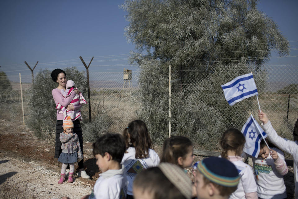 Israeli settlers gather during a visit of Israeli politicians at Gitit settlement in the West Bank’s Jordan Valley, Thursday, Jan. 2, 2014. A senior Israeli Cabinet minister and more than a dozen hawkish legislators poured cement at a construction site in a settlement in the West Bank's Jordan Valley on Thursday, in what they said was a message to visiting U.S. Secretary of State John Kerry that Israel will never relinquish the strategic area. (AP Photo/Oded Balilty)