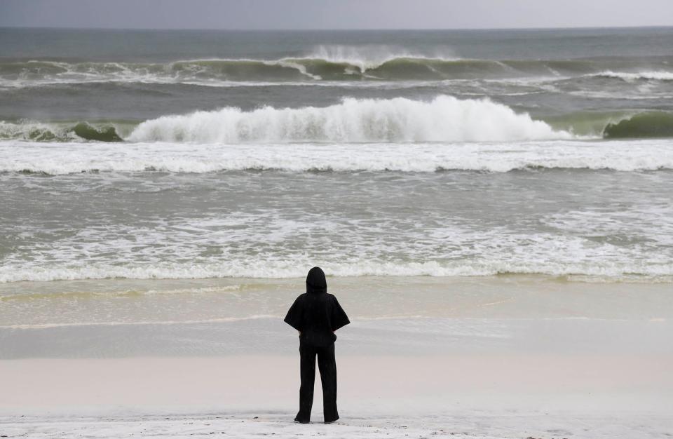 A person watches the surf in Dune Allen Beach. Walton County officials are considering new rules intended to deter beachgoers from swimming when surf conditions could potentially be life-threatening.