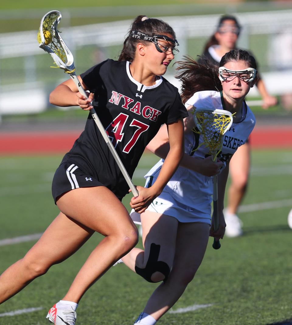 NyackÕs Ella Gould (47) drives to the goal in front of YorktownÕs Sofia Boucher (22) during girls lacrosse action at Yorktown High School May 7, 2024. Nyack won the game 10-7.