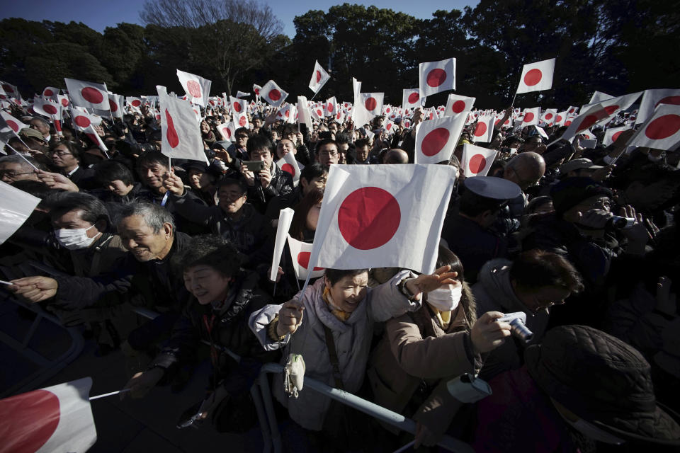 FILE - In this Dec. 23, 2014, file photo, well-wishers wave Japanese flags to celebrate Japan's Emperor Akihito's 81st birthday at the Imperial Palace in Tokyo. Japan’s future new emperor is a musician and historian who is expected to bring a global perspective to an ancient institution when he ascends the Chrysanthemum Throne on Wednesday, May 1, 2019. (AP Photo/Eugene Hoshiko, File)