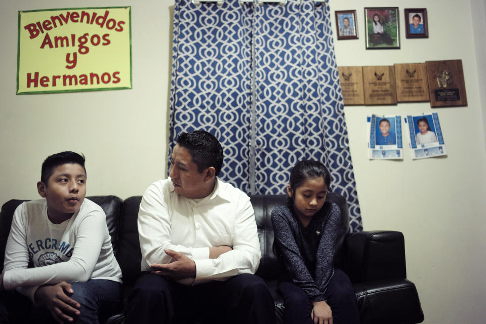 In this Nov. 21, 2019, photo Audencio Lopez, center, who crossed the border illegally as a teenager in 1997, is seated with two of his children, Anaias, 12, left, and Mercy, 8, right, during an interview with The Associated Press, at their home in Lynn, Mass. After going through the immigration court process for seven years, Lopez was told at a court hearing this past fall that the government won’t oppose granting him a visa due to his “exemplary” record and community service. But Lopez admits the family’s joy is tempered by uncertainty because his wife’s immigration status remains unresolved. (AP Photo/Steven Senne)