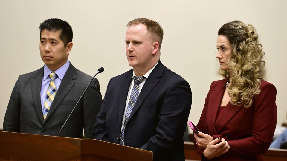 Nathan Woodyard, center, is flanked by his lawyers, Andrew Ho, left, and Megan Downing, right, during an arraignment. - Andy Cross/The Denver Post/AP