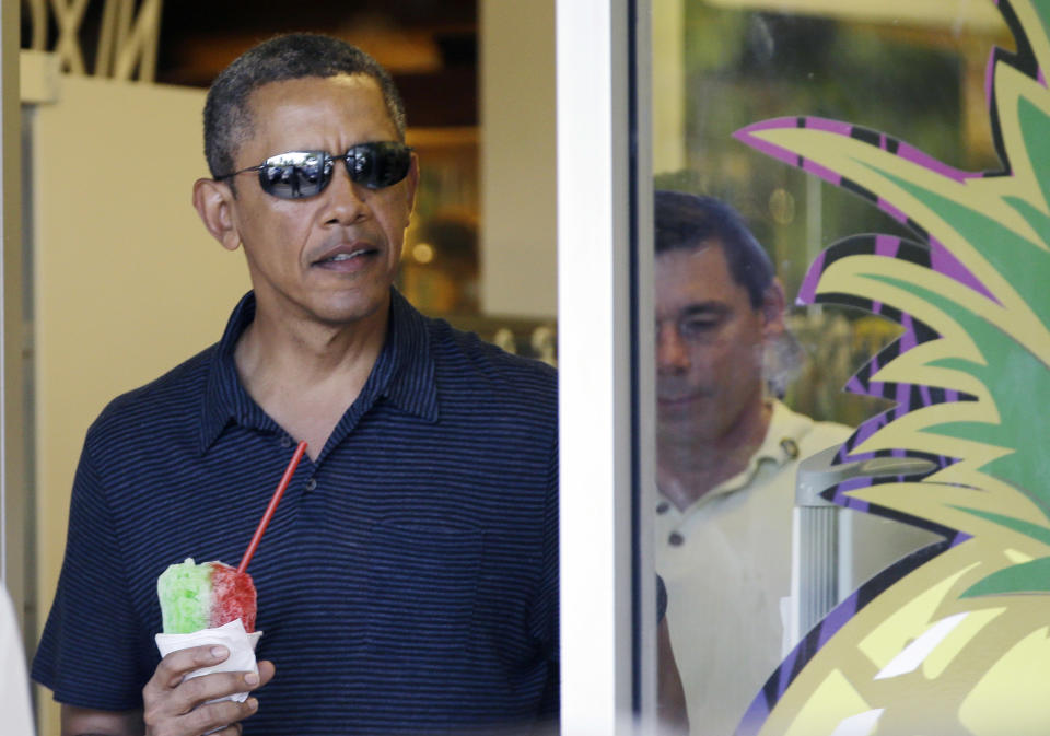 President Barack Obama holds his shave ice as he exits Island Snow to greet people waiting outside, Tuesday, Dec. 31, 2013. The first family is in Hawaii for their annual holiday vacation. (AP Photo/Carolyn Kaster)