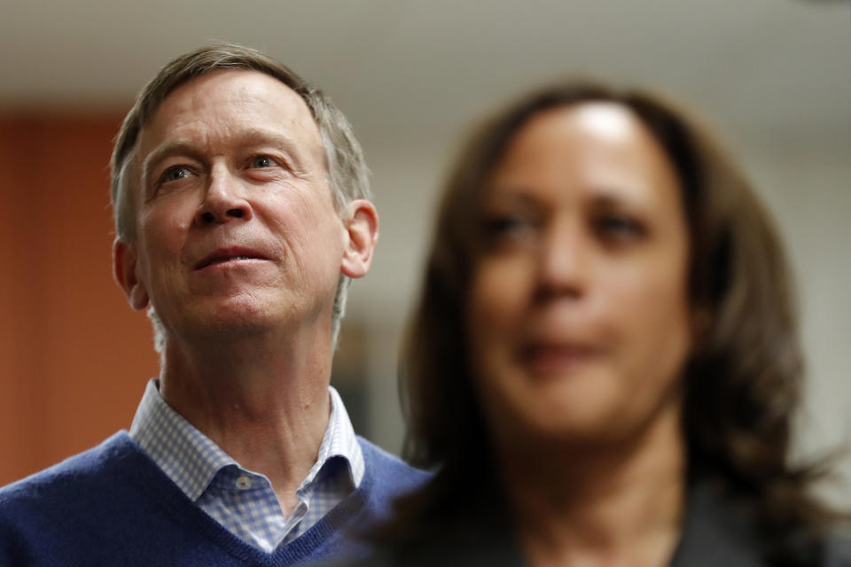 Former Colorado Gov. John Hickenlooper, left, waits to speak at the Story County Democrats' annual soup supper fundraiser, Saturday, Feb. 23, 2019, in Ames, Iowa. (AP Photo/Charlie Neibergall)