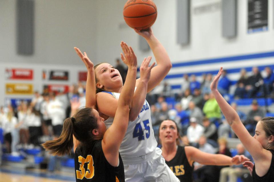 Wynford's Katie Wagner elevates over Colonel Crawford's Lynae McKibben for a basket.