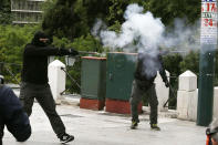 <p>Protesters aim with a flare gun to the riot police during clashes at a nationwide general strike demonstration, in Athens, May 17, 2017. Greek workers walked off the job across the country Wednesday for an anti-austerity general strike that was disrupting public and private sector services across the country. (Photo: Thanassis Stavrakis/AP) </p>