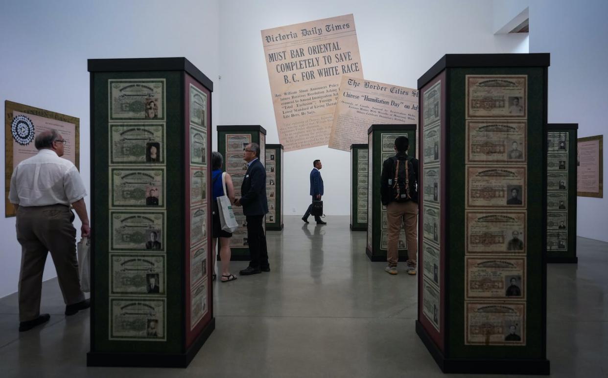 People visit the Paper Trail to the 1923 Chinese Exclusion Act exhibit at the Chinese Canadian Museum in Vancouver on June 30, 2023. The exhibit features hundreds of special identity documents called C.I. certificates that were issued to Chinese residents by the Canadian government. THE CANADIAN PRESS/Darryl Dyck
