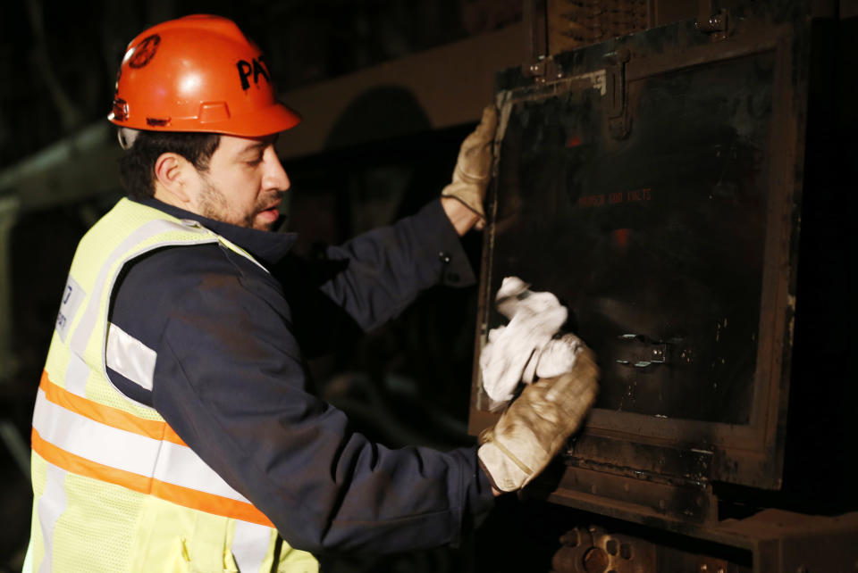 Mauricio Lopez, power railman for the PATH train system, cleans up a panel damaged by Superstorm Sandy, Tuesday, Nov. 27, 2012, in Hoboken, N.J. While other parts of the trans-Hudson service have gradually been restored since the storm, the Hoboken station has been closed, leaving thousands of commuters to seek alternatives. (AP Photo/Julio Cortez)