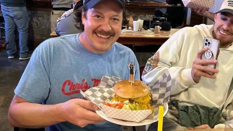 man holding up Wemby Burger