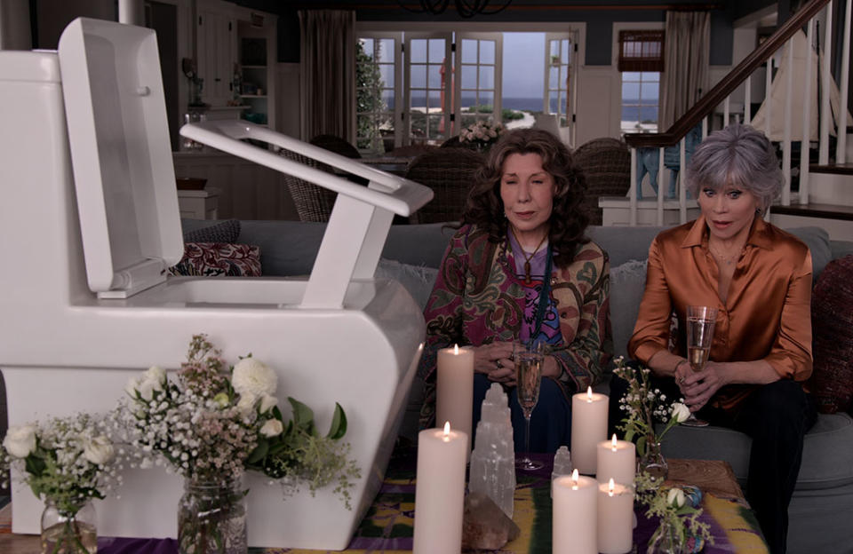 Grace and Frankie holding a memorial for a failed business venture, the Rise Up toilet, a hydraulic-powered seat to assist people on and off. - Credit: Courtesy of Netflix/NETFLIX