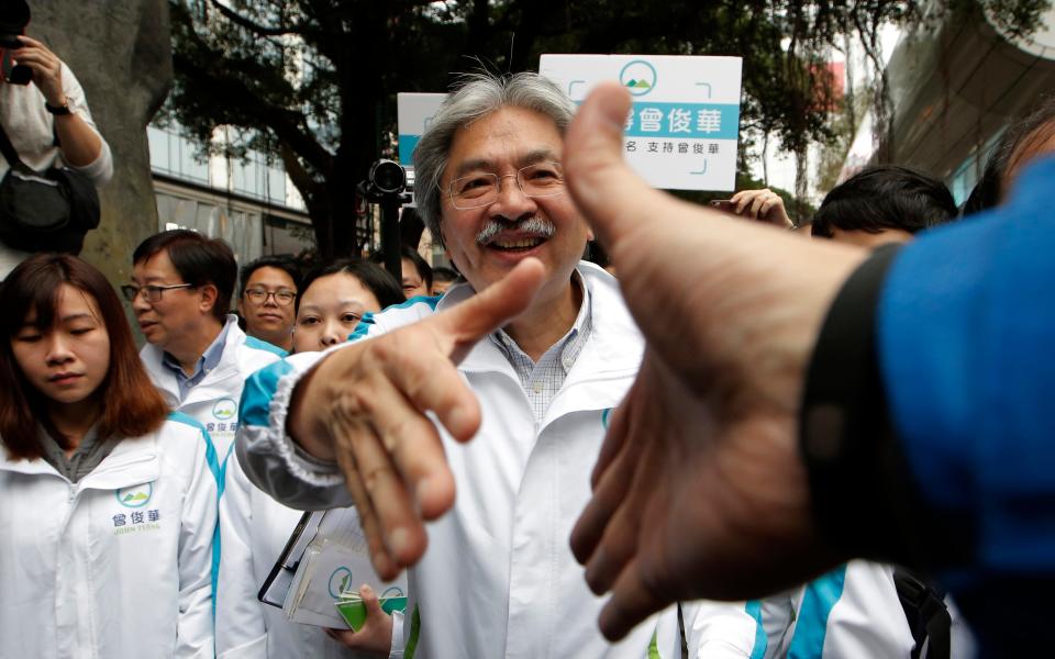 Hong Kong chief executive candidate former Financial Secretary John Tsang shakes hands with supporters  - Credit: AP