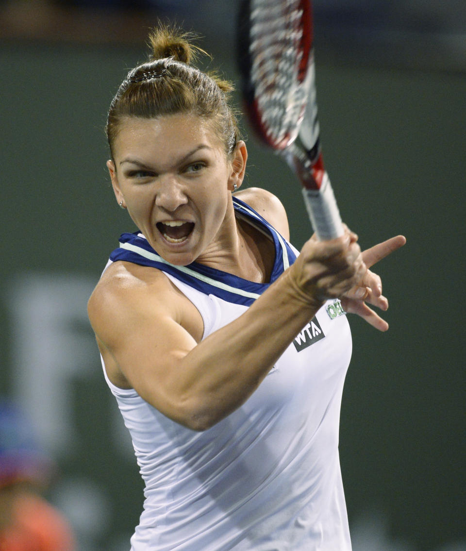 Simona Halep, of Romania, reacts after hitting to Agnieszka Radwanska, of Poland, during their semifinal match at the BNP Paribas Open tennis tournament, Friday, March 14, 2014, in Indian Wells, Calif. (AP Photo/Mark J. Terrill)