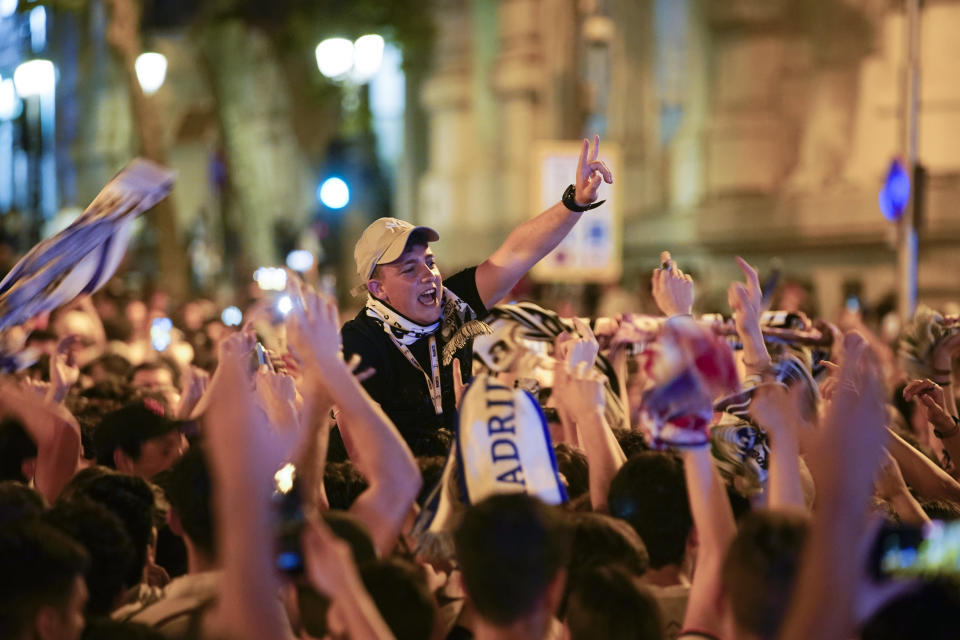 Real Madrid supporters celebrate at the end of the Champions League soccer final in Cibeles square in downtown Madrid, Spain, Sunday, May 29, 2022. Real Madrid beat Liverpool 1-0 in the Champions League final in Paris. (AP Photo/Andrea Comas)