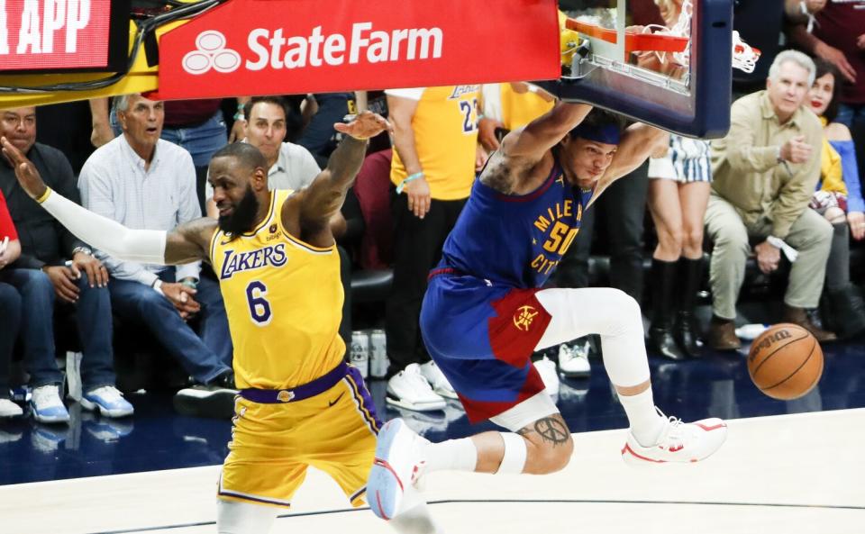 Nuggets forward Aaron Gordon, right, hangs over the edge after diving in a quick break against Lakers forward LeBron James.