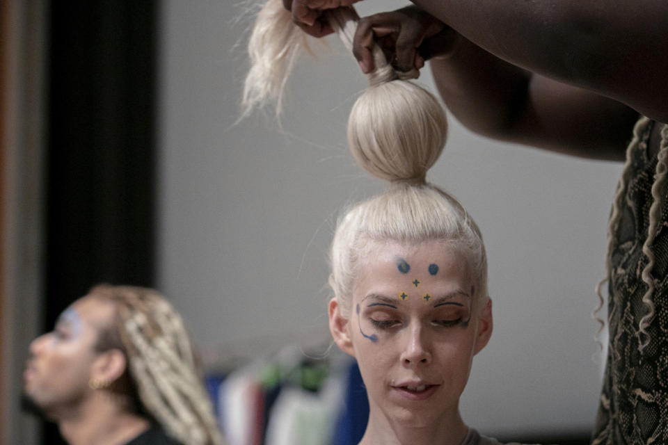 A makeup artist works on a model backstage at the dapperQ fashion show at the Brooklyn Museum on Thursday, Sept. 5, 2019, in New York. (AP Photo/Jeenah Moon)