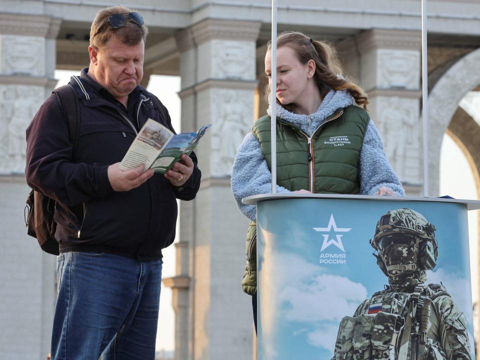 A man studies a leaflet given by a campaign member promoting Russian army service in Moscow, Russia April 12, 2023