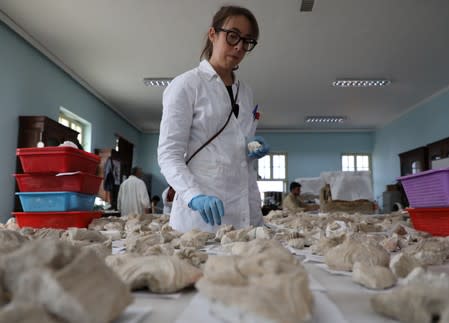 A foreigner conservator works on pieces of statues damaged by the Taliban, in Nation museum in Kabul, Afghanistan