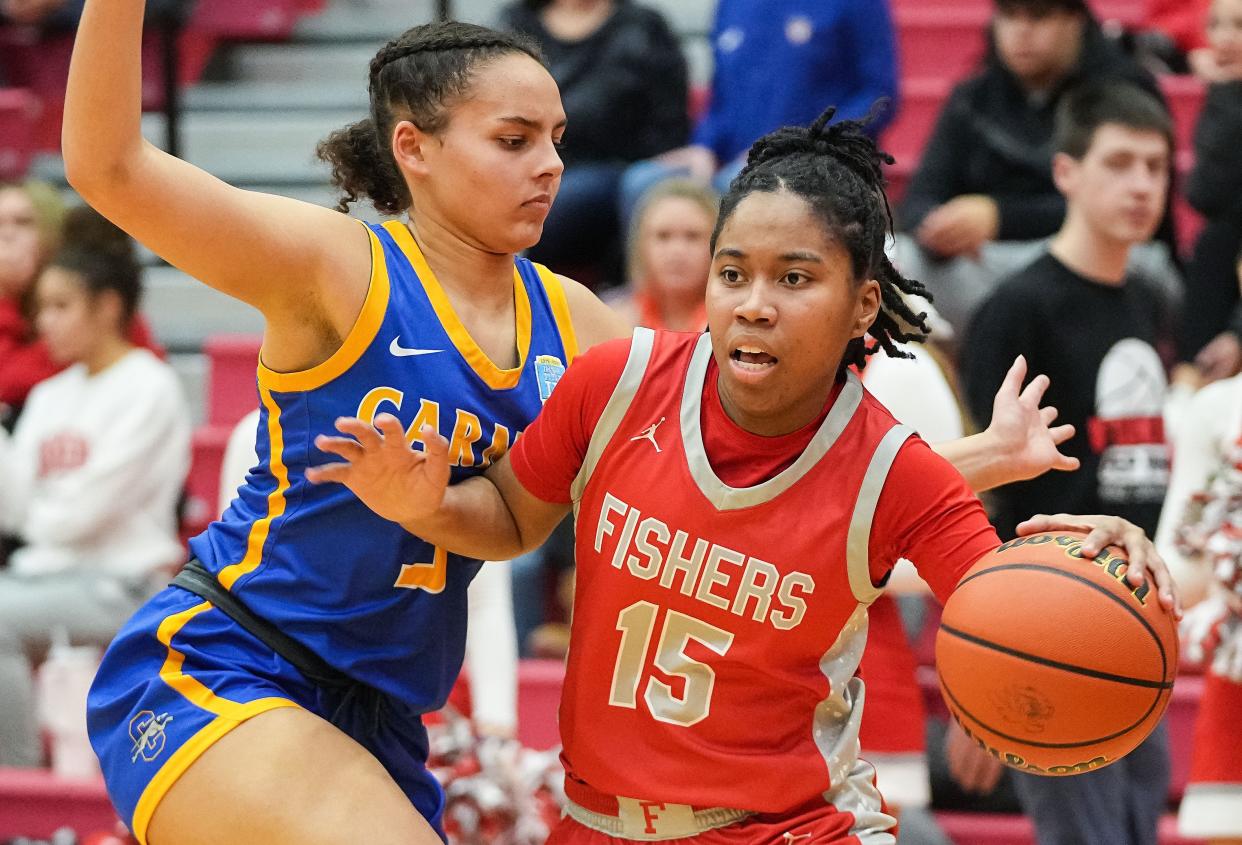 Fishers Tigers Talia Harris (15) rushes up the court against Carmel Greyhounds Keaton Gatlin (3) on Tuesday, Jan. 16, 2024, during the game at Fishers High School in Fishers. The Fishers Tigers defeated the Carmel Greyhounds, 44-37.