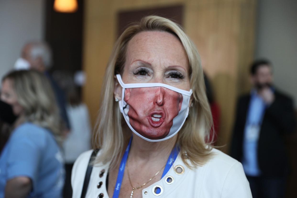 This attendee at the Conservative Political Action Conference in Orlando, Florida, heeded the mask-wearing request by the gathering's organizers. The woman, who declined to give her name, wore a covering depicting part of the face of former President Donald Trump, who speaks at the event Sunday. (Photo: Joe Raedle via Getty Images)