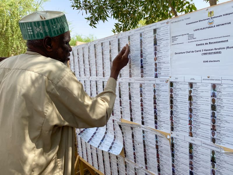 A man searches for his name on a registration list at a polling station during the presidential election in N'Djamena