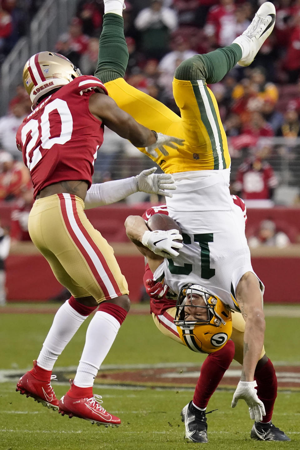 Green Bay Packers wide receiver Allen Lazard (13) falls to the ground between San Francisco 49ers free safety Jimmie Ward (20) and Emmanuel Moseley during the first half of the NFL NFC Championship football game Sunday, Jan. 19, 2020, in Santa Clara, Calif. (AP Photo/Tony Avelar)