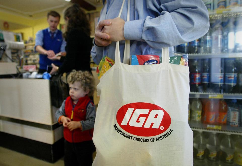 IGA bag around man's shoulder in supermarket