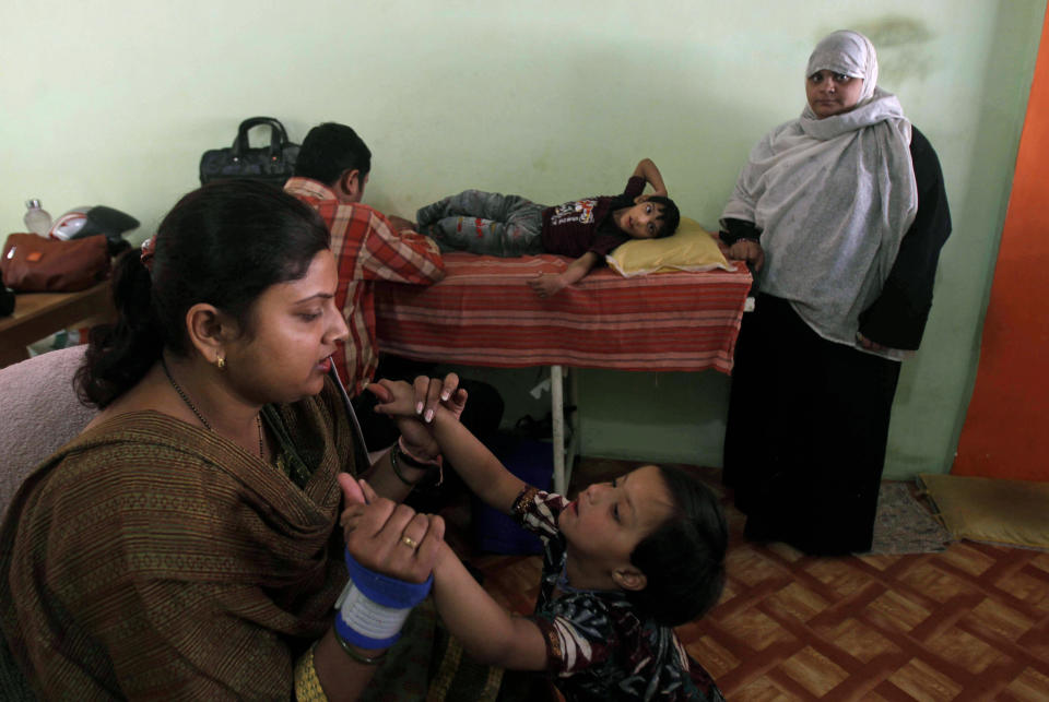 In this photo taken Tuesday, March 13, 2012, Suhana, 4, foreground, born mentally and physically disabled, a second generation victim of 1984 gas leak at the Union Carbide plant, goes through a physiotherapy session at a clinic, in Bhopal clinic in Bhopal, India. The survivors of the tragedy of 27 years ago, with their lingering illnesses, sick children and dead relatives, faded away from the world's memory, even as their suffering went on. Now, though, they have seized on a new chance to force their plight in front of the world, the London Olympics. (AP Photo/Rafiq Maqbool)