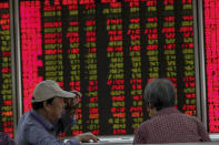 Chinese investors monitor stock prices at a brokerage house in Beijing, Thursday, Sept. 19, 2019. Shares were mixed in Asia on Thursday, with Tokyo and Sydney logging modest gains after the Federal Reserve cut its benchmark interest rate for a second time this year, citing slowing global economic growth and uncertainty over U.S. trade conflicts. (AP Photo/Andy Wong)
