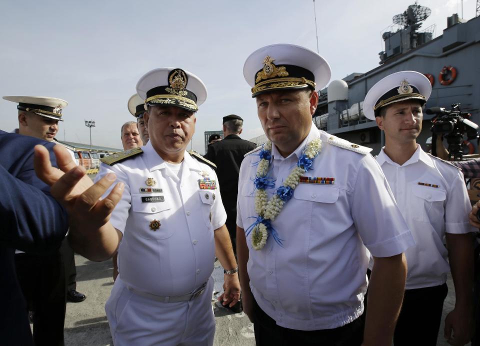 Philippine Navy Commander, Naval Combat Engineering Brig. Francisco Gabudao Jr., left, gestures beside Russian Rear Adm. Eduard Mikhailov, Deputy Commander of Flotilla of Pacific Fleet of Russia, as the Russian Navy vessel Admiral Tributs, a large anti-submarine ship, docks at Manila's pier, Philippines on Tuesday, Jan. 3, 2017. Two Russian Navy Vessels are in the country for a goodwill visit till Jan. 7. (AP Photo/Aaron Favila)