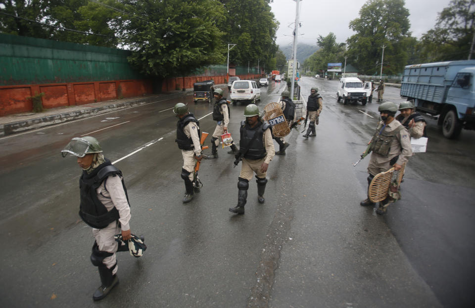 Indian security officers patrol a street in Srinagar, Indian controlled Kashmir, Saturday, Aug. 10, 2019. Authorities enforcing a strict curfew in Indian-administered Kashmir will bring in trucks of essential supplies for an Islamic festival next week, as the divided Himalayan region remained in a lockdown following India's decision to strip it of its constitutional autonomy. The indefinite 24-hour curfew was briefly eased on Friday for weekly Muslim prayers in some parts of Srinagar, the region's main city, but thousands of residents are still forced to stay indoors with shops and most health clinics closed. All communications and the internet remain cut off. (AP Photo/Mukhtar Khan)