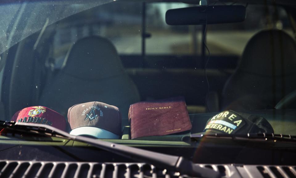 A Bible and a Korean War Veteran baseball cap sit on the dashboard of a pickup truck parked along the Main Street business district in Lula, Ga., in Hall County, Tuesday, Jan. 10, 2017. Even with a growing Hispanic population, Hall County is whiter than Georgia and the United States as a whole, and white conservatism carries the day. (AP Photo/David Goldman)