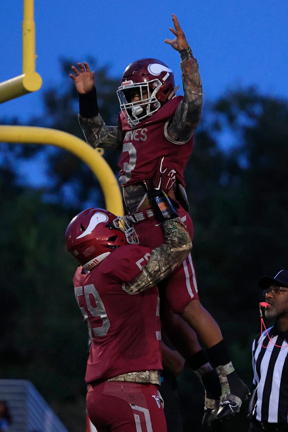 Raines' Mark Miller (3) is celebrated after his touchdown score by Antonio Allen (59) during the second quarter of a high school football matchup Friday, Oct. 6, 2023 at Raines High School in Jacksonville, Fla. The Raines Vikings edged the First Coast Buccaneers 27-26. [Corey Perrine/Florida Times-Union]
