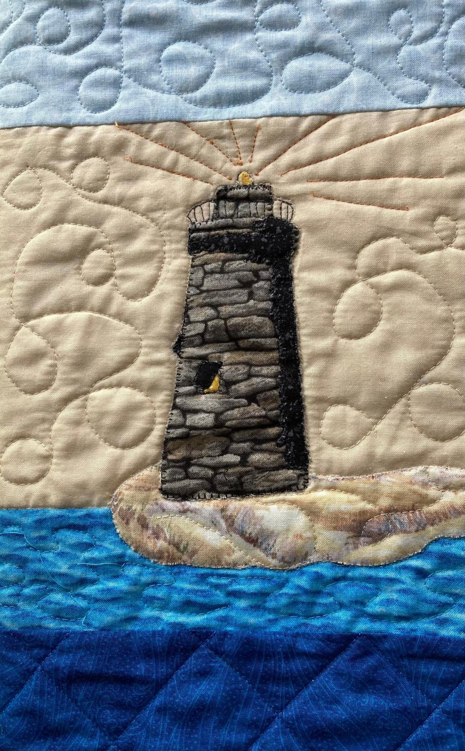 Closeup of the landmark lighthouse on Queen Lake in the quilt designed by Barbara Sanden for Don Wilson.