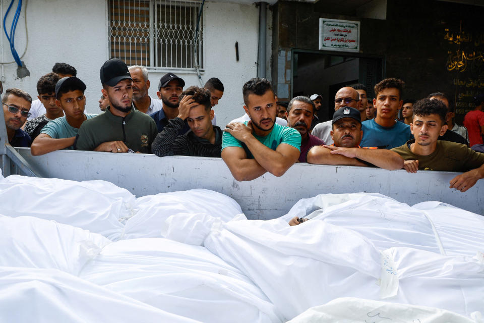 Palestinians mourn alongside the bodies of those killed in Israeli airstrikes in Gaza City on Monday. (Mohammed Salem/Reuters)