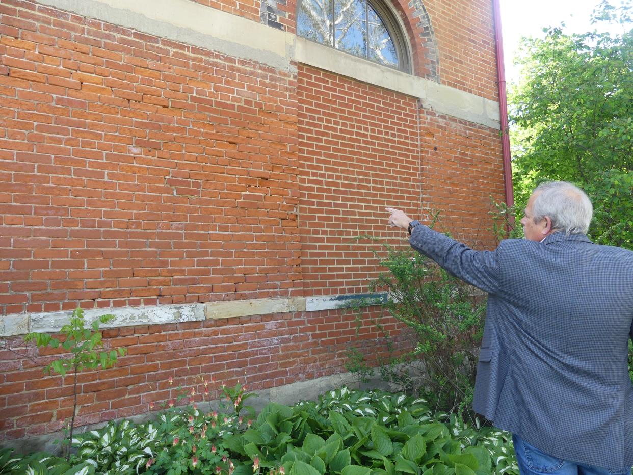 Director of the Pump House John Payne shows some of the damaged bricks on the building. He said this damage goes all around the building.