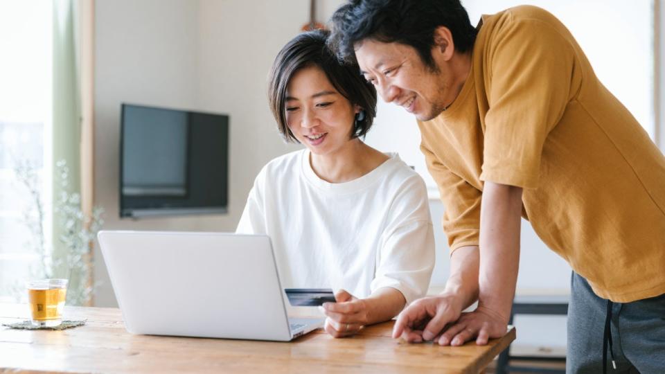 Asian couple using a credit card for internet shopping