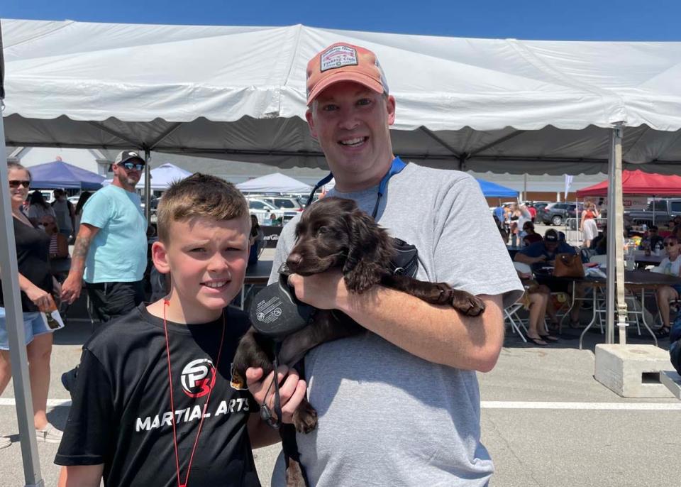 Lily the baby Boykin Spaniel seems to be enjoying the day with his humans Brock Whitt and dad Paul Whitt. Paul said Lily is destined for Dock Diving when she’s older. 
Dog Daze VI was held at Village Green Shopping Center in Farragut Saturday, Aug. 13, 2022.