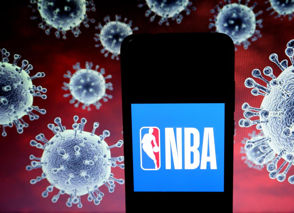 KOLKATA, INDIA - 2020/03/25: In this photo illustration a National Basketball Association (NBA) logo seen displayed on a smartphone with a computer model of the COVID-19 coronavirus in the background. (Photo Illustration by Avishek Das/SOPA Images/LightRocket via Getty Images)