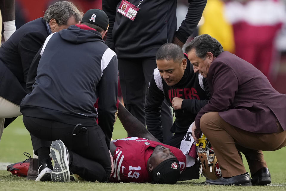 San Francisco 49ers wide receiver Deebo Samuel, bottom, is checked on before being carted off during the first half of an NFL football game against the Tampa Bay Buccaneers in Santa Clara, Calif., Sunday, Dec. 11, 2022. (AP Photo/Tony Avelar)