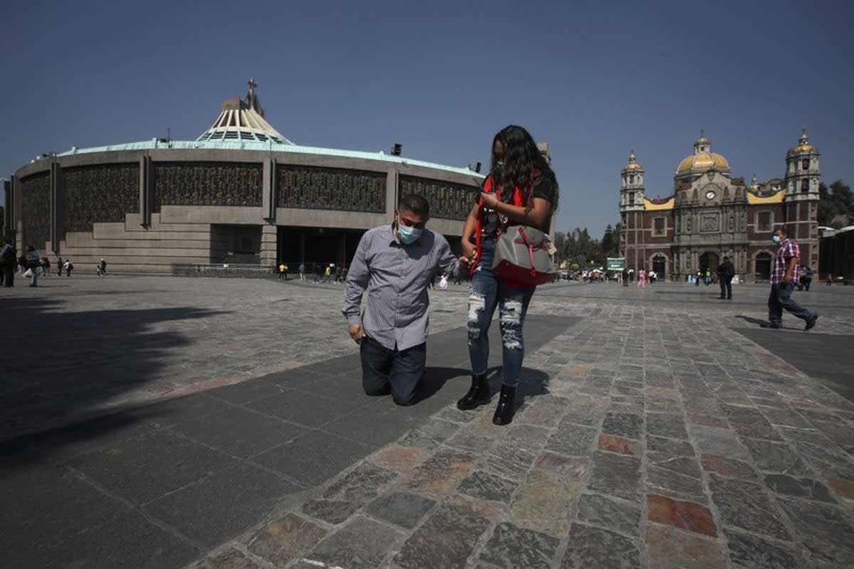 Un devoto de la Virgen de Guadalupe, con cubrebocas para protegerse del coronavirus, avanza hincado el martes 24 de noviembre de 2020 en la Basílica de Guadalupe, en la Ciudad de México. (AP Foto/Marco Ugarte)