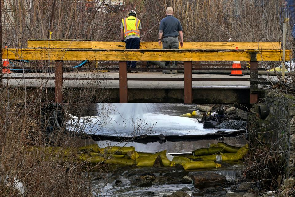 HEPACO workers, an environmental and emergency services company, observe a stream in East Palestine, Ohio (AP)