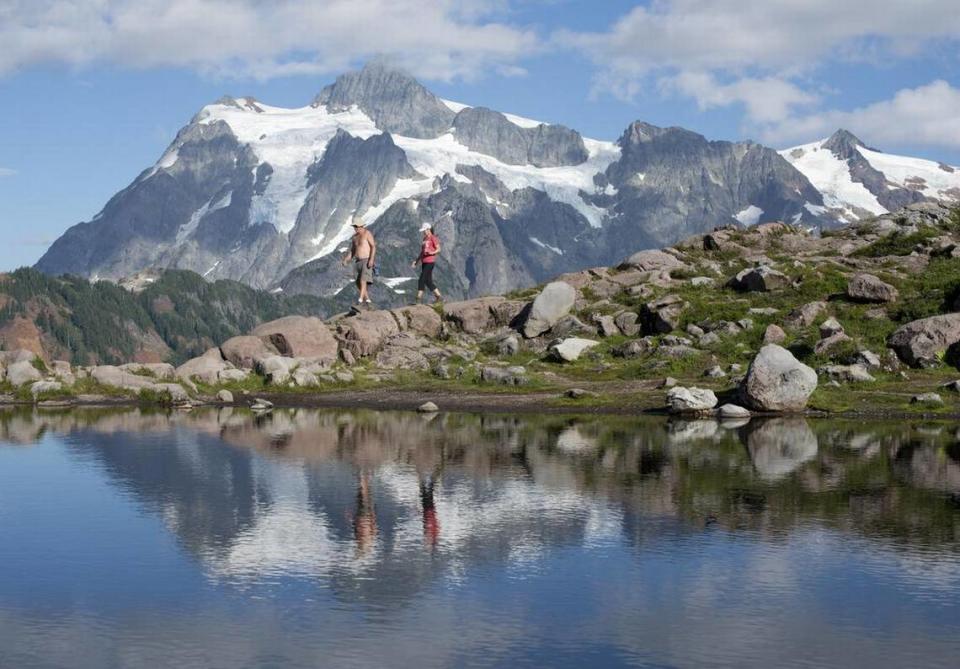 Rick Paul, left, and Sue Toy, right, walk along the Artist Ridge Trail, Aug. 26, 2014 at Artist Point. This week’s rain could complicate plans for a late-summer hike in the North Cascades, as forecasters say that snow will fall to elevations as low as 5,000 feet.