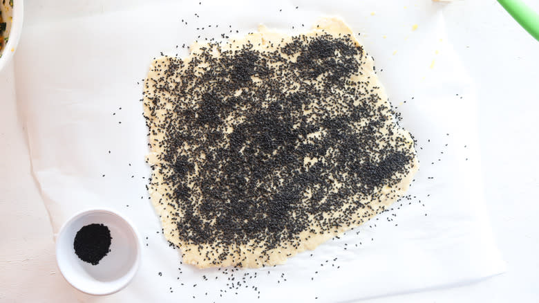 dough sheet sprinkled with sesame seeds