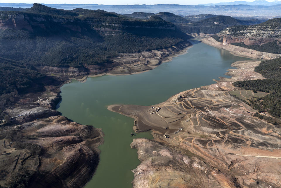 View of the Sau reservoir, which is only at 5 percent of its capacity, in Vilanova de Sau, about 100 km (62 miles) north of Barcelona, Spain, Friday, Jan. 26, 2024. Barcelona and the surrounding area of Spain's northeast Catalonia are preparing to face tighter water restrictions amid a historic drought that has shrunk reservoirs to record lows. Catalonia has recorded below-average rainfall for 40 consecutive months. Experts say that the drought is driven by climate change and that the entire Mediterranean region is forecast to heat up at a faster rate than many other regions in the coming years. (AP Photo/Emilio Morenatti)