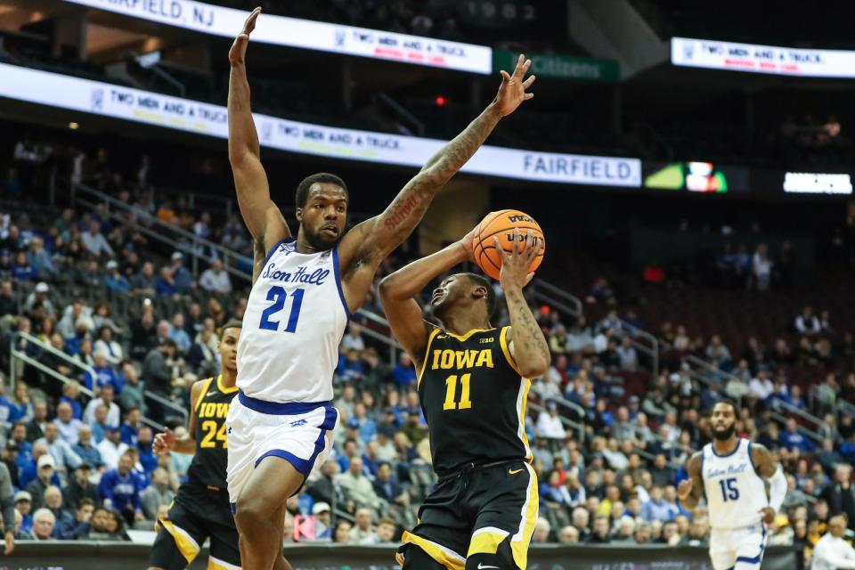 Iowa Hawkeyes guard Tony Perkins (11) attempts to drive past Seton Hall Pirates guard Femi Odukale (21) in the first half at Prudential Center.